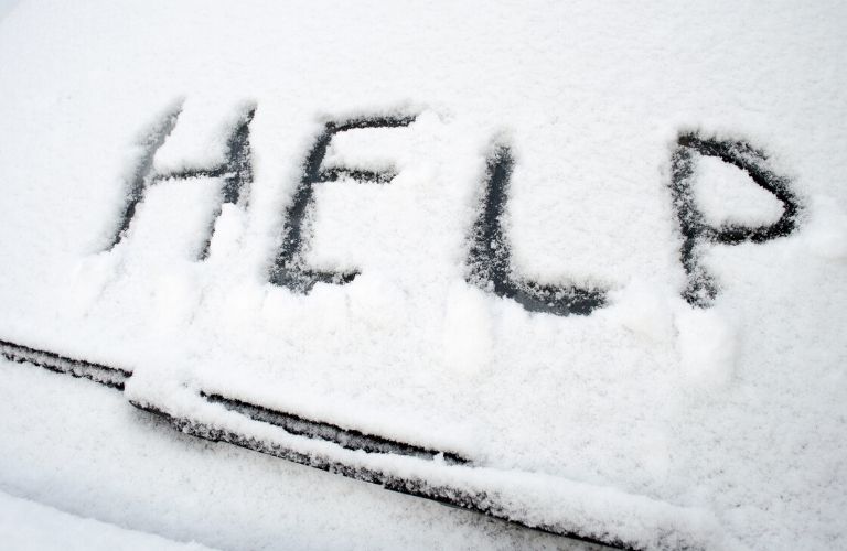 Help written in snow on window